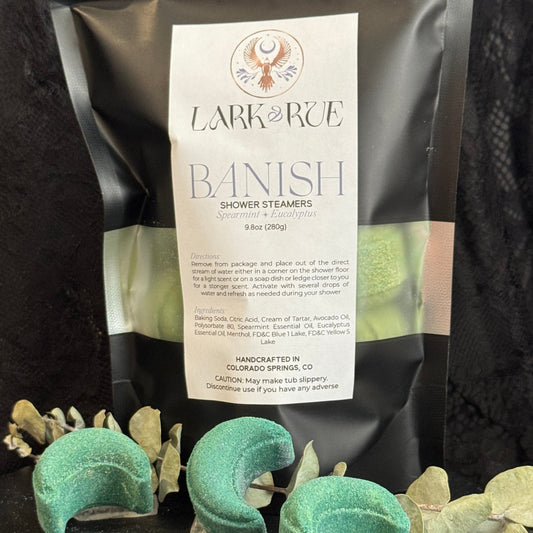 Image of black pouch filled with green crescent moon shower steamers on dark background.