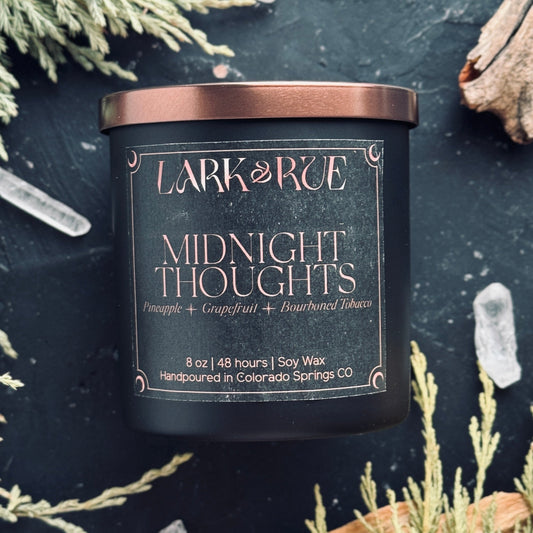Midnight Thoughts by Lark & Rue on a dark background with dried cedar and quartz points.