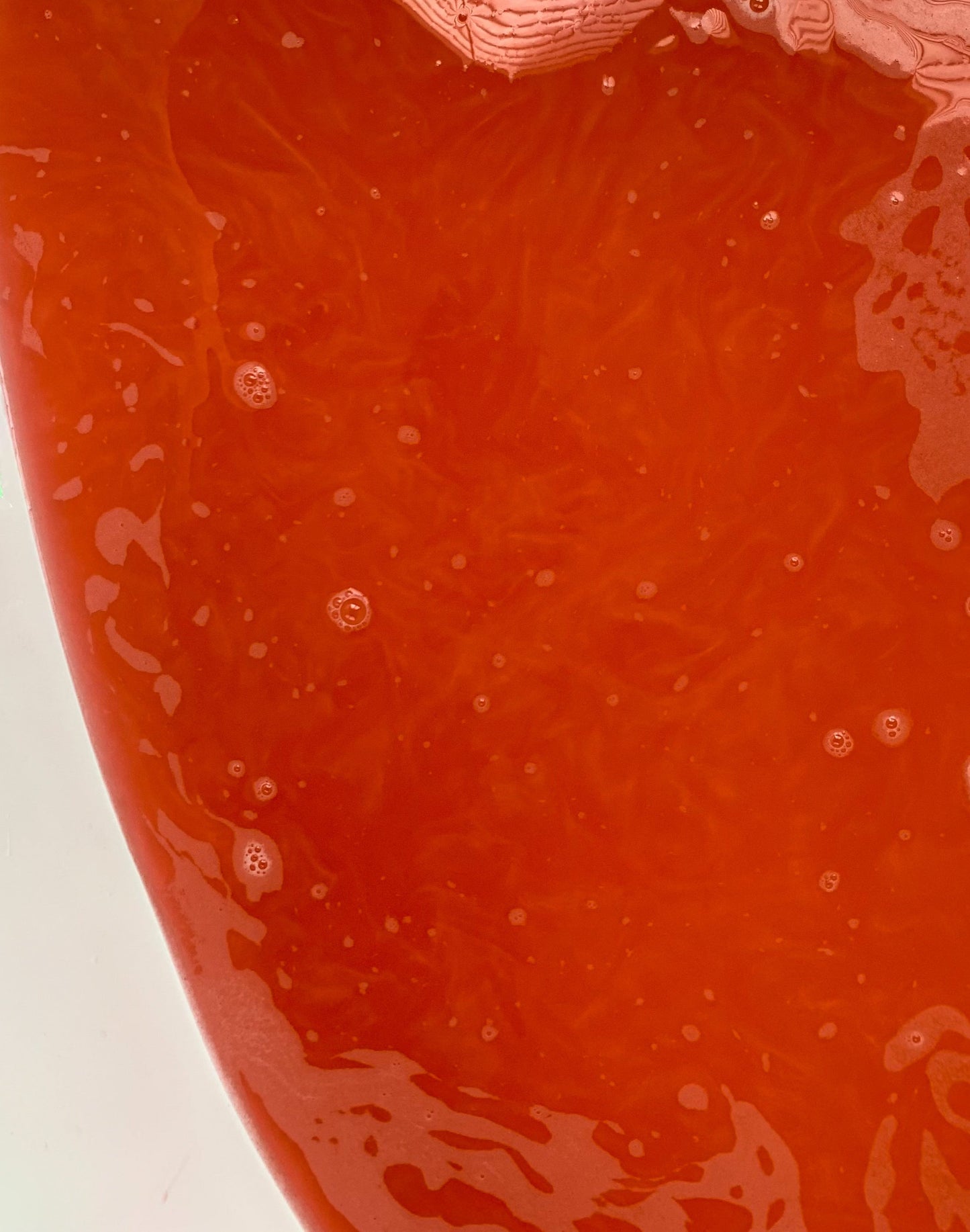 Close up of red bath water with mica shimmer