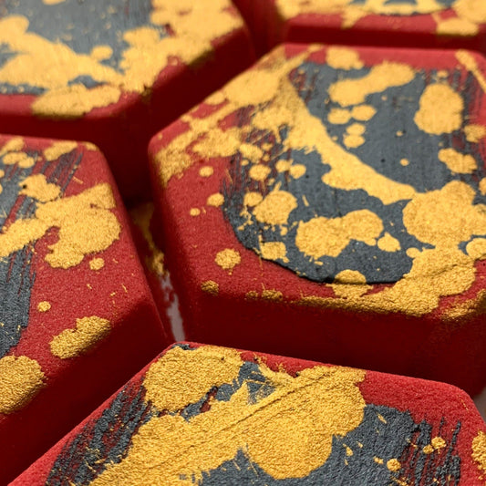 Rebellion Bath Bomb. Red hexagon with hand-painted black mica brush stroke and gold mica splatter